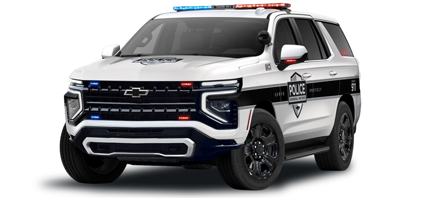 A modern white police SUV with black detailing, emergency lights on the roof and front grille, and police markings on the side. Description generated by AI